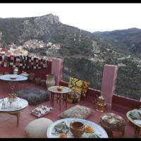 a balcony with tables and chairs with mountains in the background at Riad lala zakia, Moulay Idriss