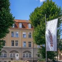 a building with a flag in front of it at REGIOHOTEL Quedlinburger Hof Quedlinburg