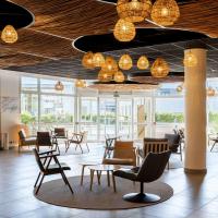 a lobby with chairs and tables and lights at Mercure Compiègne Sud