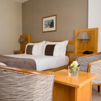 a hotel room with a bed and a table and chairs at Hotel Rainha D. Amélia, Arts & Leisure, Castelo Branco
