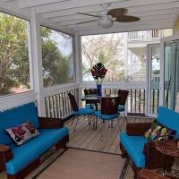 a screened in porch with blue chairs and a table at Beautiful apartment with terrace, free Wifi, Contadora