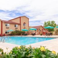 a pool at a hotel with tables and umbrellas at Aarchway Inn, Moab