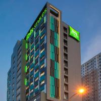 a tall building with a green sign on it at ibis Styles Bekasi Jatibening