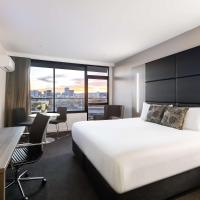 a hotel room with a bed and a desk at Rydges South Park Adelaide
