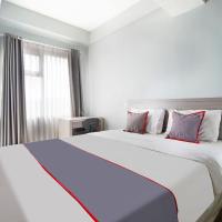 a bedroom with a large white bed with red pillows at Super OYO 91566 Easton Park Jatinangor, Sayang