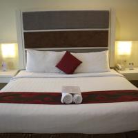 a bedroom with a large bed with two towels on it at President Executive Club, Cikarang
