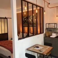 a room with a bed and a table and a kitchen at Les lofts, L'Isle-sur-la-Sorgue