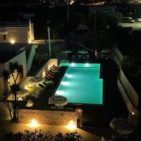 a swimming pool at night with chairs and lights at Tuo Hotel, Polignano a Mare