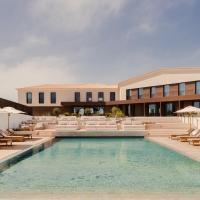 a hotel with a pool and chairs and a building at Aethos Ericeira
