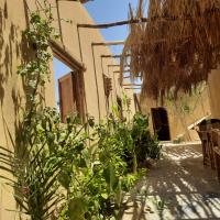 a courtyard with plants and a building at Tunis Ecolodge, Fayoum