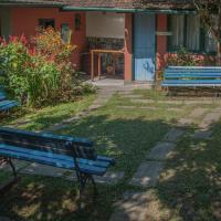 two blue benches sitting in front of a house at Pousada Flor do Mato, Lumiar