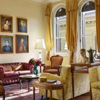 a living room with couches and portraits on the wall at Hotel Pendini, Florence