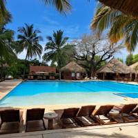 a large swimming pool with chairs and palm trees at Neptune, Saly Portudal