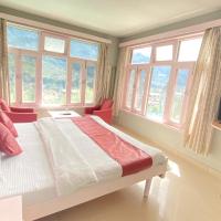 a bedroom with a bed and windows and a television at Hotel Meadows Manali, Manāli