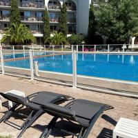 a table and chairs next to a swimming pool at Hotel Résidence Anglet Biarritz-Parme
