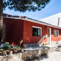 a red house with a tree in front of it at Separate guest house near Madrid, Moralzarzal