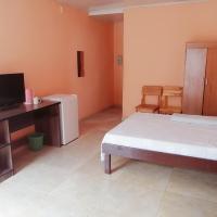 a bedroom with a bed and a desk with a television at Prosperous Guest House, Opuwo