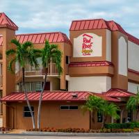 a hotel building with palm trees in front of it at Red Roof Inn PLUS+ & Suites Naples Downtown-5th Ave S