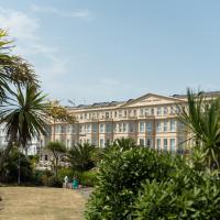 a large building with palm trees in front of it at The Lansdowne Hotel, Eastbourne