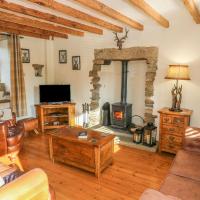 a living room with a fireplace and a couch at Daisy Cottage, Barnoldswick