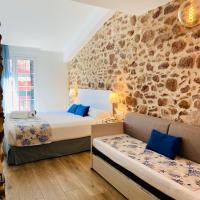 a bedroom with two beds and a stone wall at Soléa House Hotel Boutique, Benicàssim
