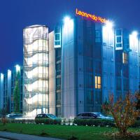 a lit up building with a hotel sign on it at Leonardo Hotel Hannover Airport