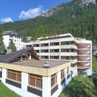 a hotel building with a mountain in the background at Hotel Astoria, Leukerbad