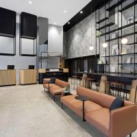 a lobby with couches and chairs and a bar at Travelodge Hotel Melbourne Docklands