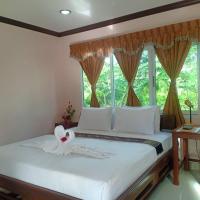 a bedroom with a bed with white sheets and a window at Capital O 75415 Nanthachart Riverview Resort, Samut Songkhram