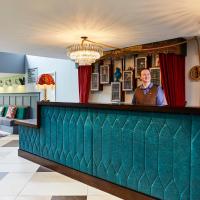 a man standing behind the bar of a restaurant at Hotel Indigo - Stratford Upon Avon, an IHG Hotel, Stratford-upon-Avon