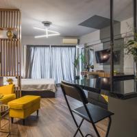 a living room with a yellow chair and a bedroom at K-Houses A4, Arta