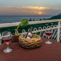 a table with two glasses of wine and a basket of wine bottles at Sunny views & Dreamy Sunsets by BS, Agios Gordios