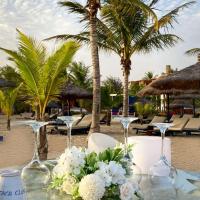 a table with wine glasses and flowers on a beach at Lamantin Beach Resort And Spa Managed By Accor, Saly Portudal