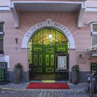 a front door of a pink building with a green door at St.Olav Hotel, Tallinn