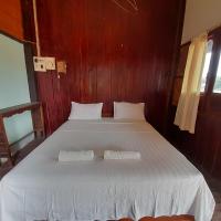 a bedroom with a large white bed with two pillows at Rivergarden Guesthouse and restaurant, Don Det