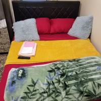 a bed with a yellow and red blanket and a laptop on it at COZY & ALL PRIVATE SPACE close to RUMC & SIUH, Staten Island