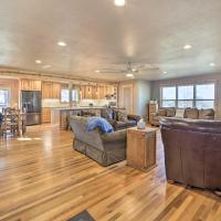 a large living room with wooden floors and a kitchen at Claremore Country Home with Large Yard and Grill!