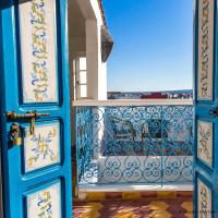 a blue door with a balcony with a view at Hôtel Emeraude Essaouira