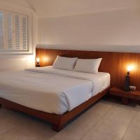 a large bed in a bedroom with two lamps at Benyada Lodge - Surin Beach