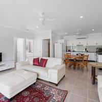 a living room with a white couch and a table at Cardwell Seascape Apartments