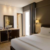 a bedroom with a bed and a desk with a mirror at Piraeus City Hotel
