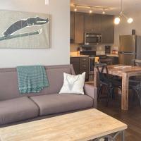 a living room with a couch and a table and a kitchen at Mountainside Living, Crested Butte