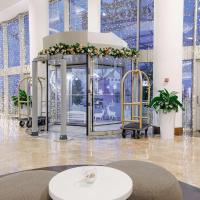 a lobby with a large room with windows and a table at Radisson Blu Resort & Congress Centre 5*, Adler