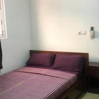 a small bed in a small room with purple sheets at Villa 34, Cocody