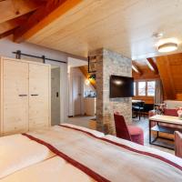 a bedroom with a large bed in a room with wooden ceilings at Sonne Andermatt Swiss Quality Hotel