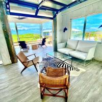 a living room with a couch and a table and chairs at Rooster Beach - Hope Town, Elbow Cay, Lubbers Quarters Cay