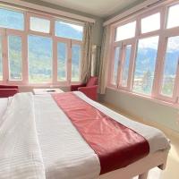 a bedroom with a large bed with windows at Hotel The Meadows Open Terrace Bonfire, Manāli