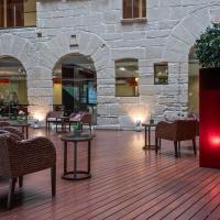 a lobby with chairs and tables and a stone wall at F&G Logroño