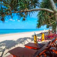 a beach with chairs and a tree and the ocean at Lanta Miami Resort - SHA Extra Plus, Ko Lanta
