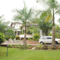a white car parked in front of a house with palm trees at Kiriri Residence Hotel, Bujumbura